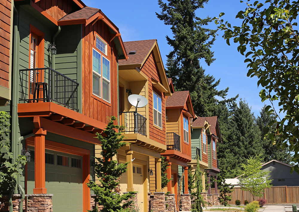 Colorful condominium apartments surrounded by mountains and trees.