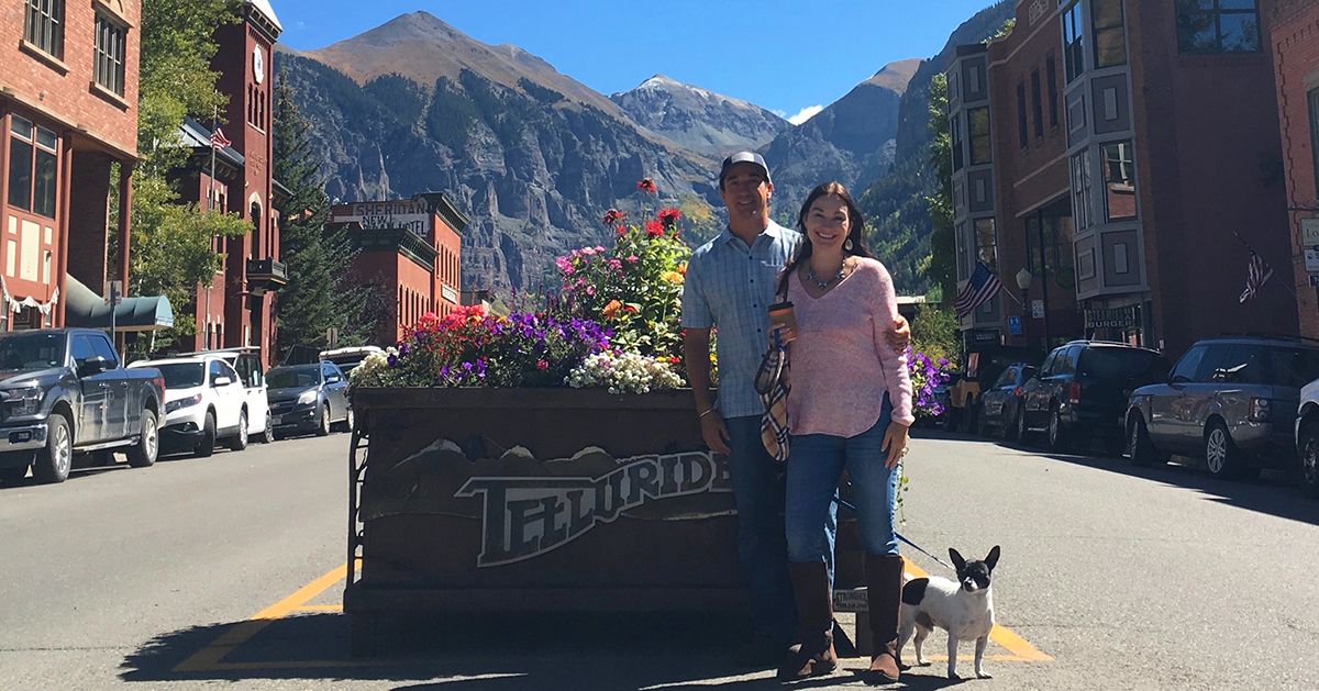 Colorado home inspector David Pace standing with his wife and dog in front of mountains and a small town.